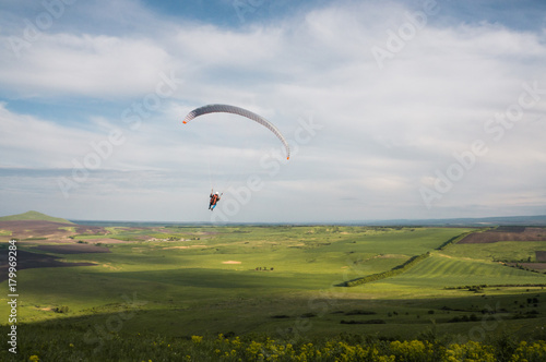 Paraglider flying above field