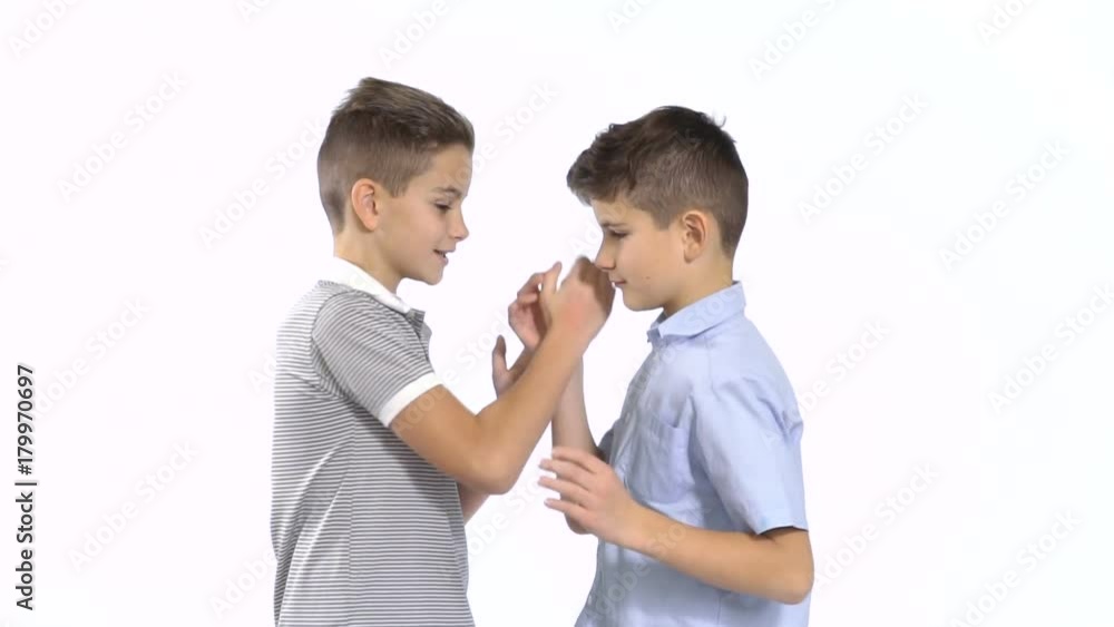Two little brothers shakes hands at white background Two little brothers shakes hands at white background