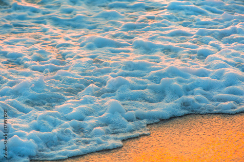 White foam on sandy beach background texture