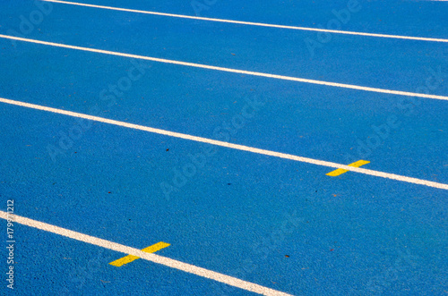 blue running track with white lines on athletic stadium