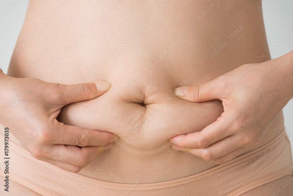 Naklejka premium woman squeezes belly fat