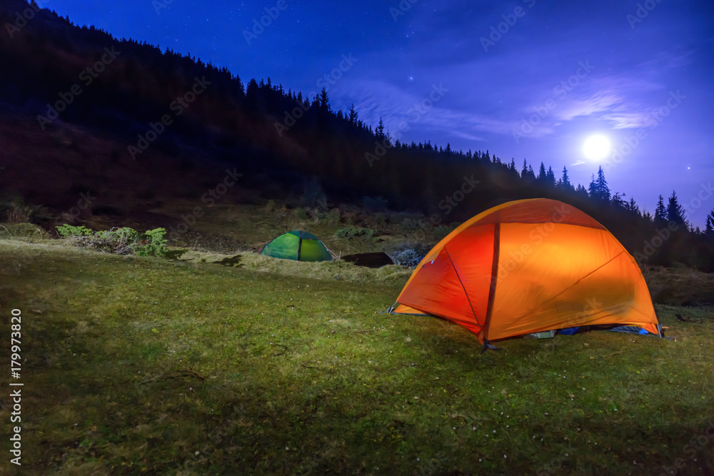 Two Illuminated orange and green camping tents Two Illuminated orange and green camping tents