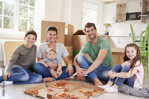 Portrait Of Family Celebrating Moving Into New Home With Pizza