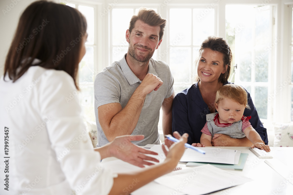 Family With Baby Meeting Financial Advisor At Home