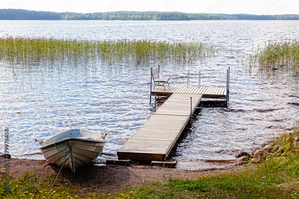 Naklejka premium Jetty and boat are on lake in summer day