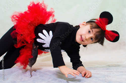 Fotografi cute little girl in a bear costume with ears holds a hand rat