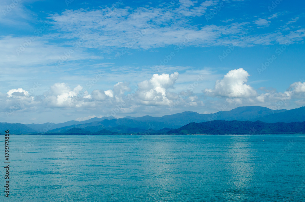 Horizontal of Seascape including Forest Mountain, Blue Sky and Wave of Water Foam in Ocean. Horizontal of Seascape including Forest Mountain, Blue Sky and Wave of Water Foam in Ocean.