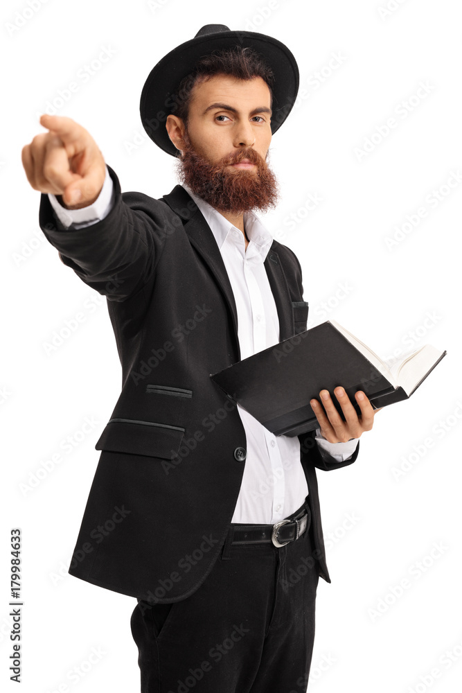 Religious man with a book pointing at the camera Religious man with a book pointing at the camera