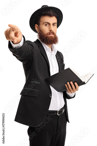 Religious man with a book pointing at the camera