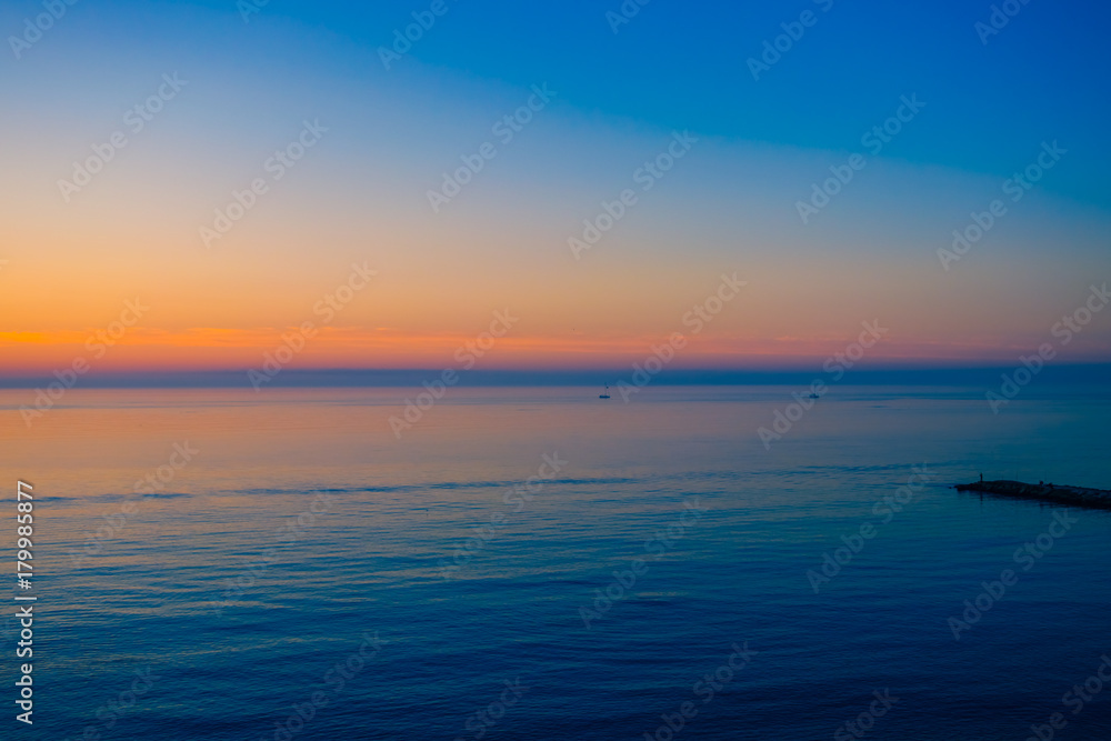Sunrise over a quiet calm sea.
