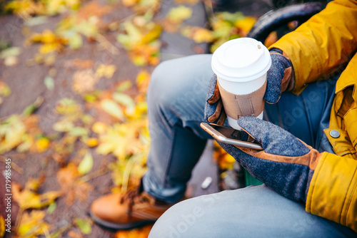 young man drinking hot coffee outdoors in cold autumn day