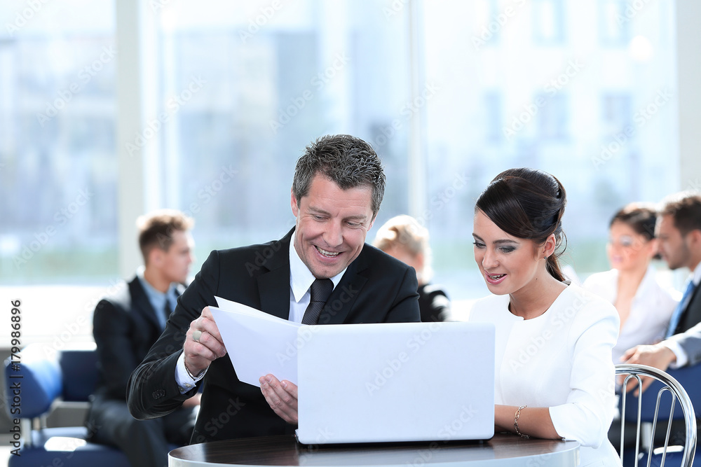 business partners discussing documents, sitting at the table.