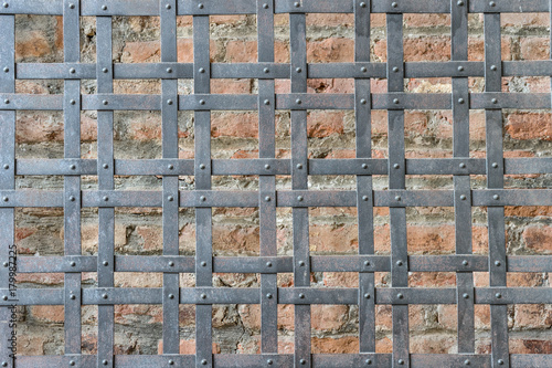 Old metal lattice / Old metal lattice in front of a wall with red bricks 