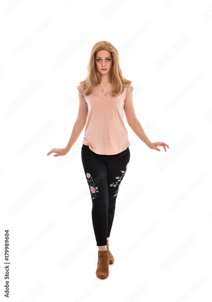full length portrait of a girl wearing pink shirt and black floral pants. standing pose, isolated on white background. full length portrait of a girl wearing pink shirt and black floral pants. standing pose, isolated on white background.