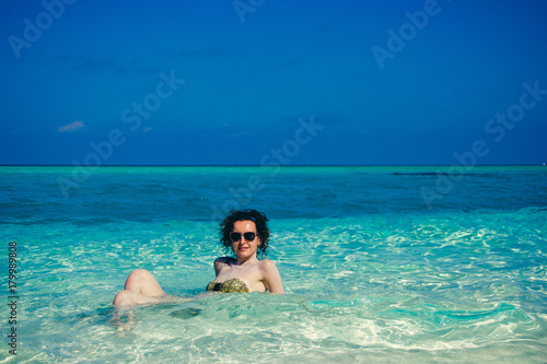 Idyllic paradise island landscape. Exotic tropical beach. Summer vacation  luxury holiday resort  tourism concept. Travel to Maldives. Young woman sunbathing in turquoise crystal clear water.Copyspace