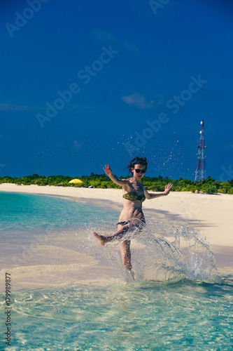 Woman splash water. Idyllic paradise island landscape. Exotic tropical beach. Summer vacation, luxury holiday resort, tourism concept. Travel destination. Seascape with white sand, turquoise water.