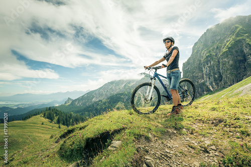 Germany, Bavaria, Pfronten, woman with mountain bike on alpine meadow near Aggenstein