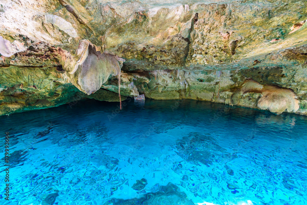 Cenote Dos Ojos in Quintana Roo, Mexico. People swimming and snorkeling in clear blue water. This cenote is located close to Tulum in Yucatan peninsula, Mexico.