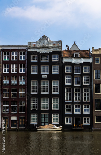 Ein Boot an einer Gracht in Amsterdam liegt an einem Steeg eines Stadthauses , Niederlande