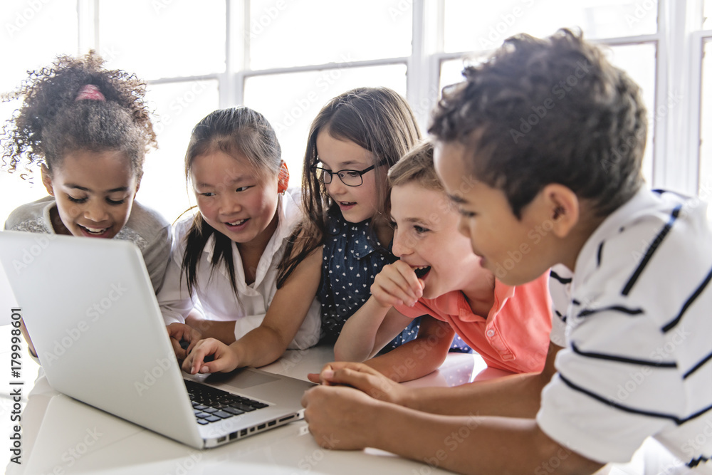 Group of curious children watching stuff on the laptop screen Group of curious children watching stuff on the laptop screen
