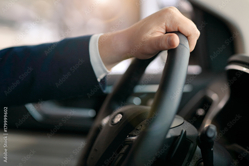 Male hand on a steering wheel
