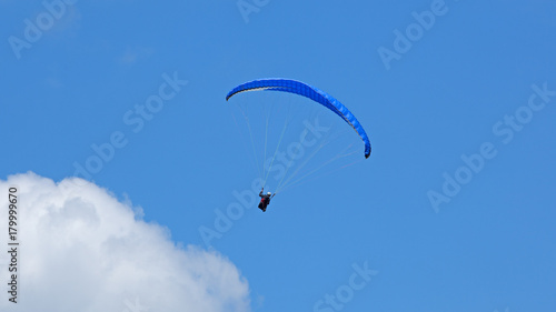  Vol de parapente sur fond de ciel bleu en montagne. Deltaplane au dessus des nuages.