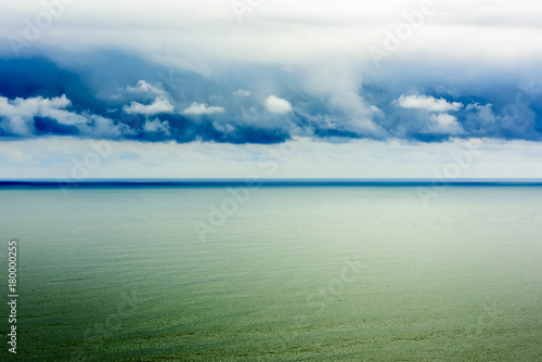 Stylized abstract landscape seascape sunset long exposure with clouds under different shades of blue, orange, yellow and red.