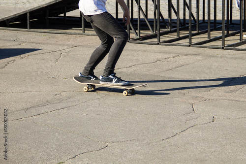 Skateboarder legs riding skateboard at skatepark © olyasolodenko