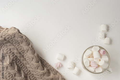 Warm cozy sweater and marshmallow. Winter concept. Flat lay. Top view
