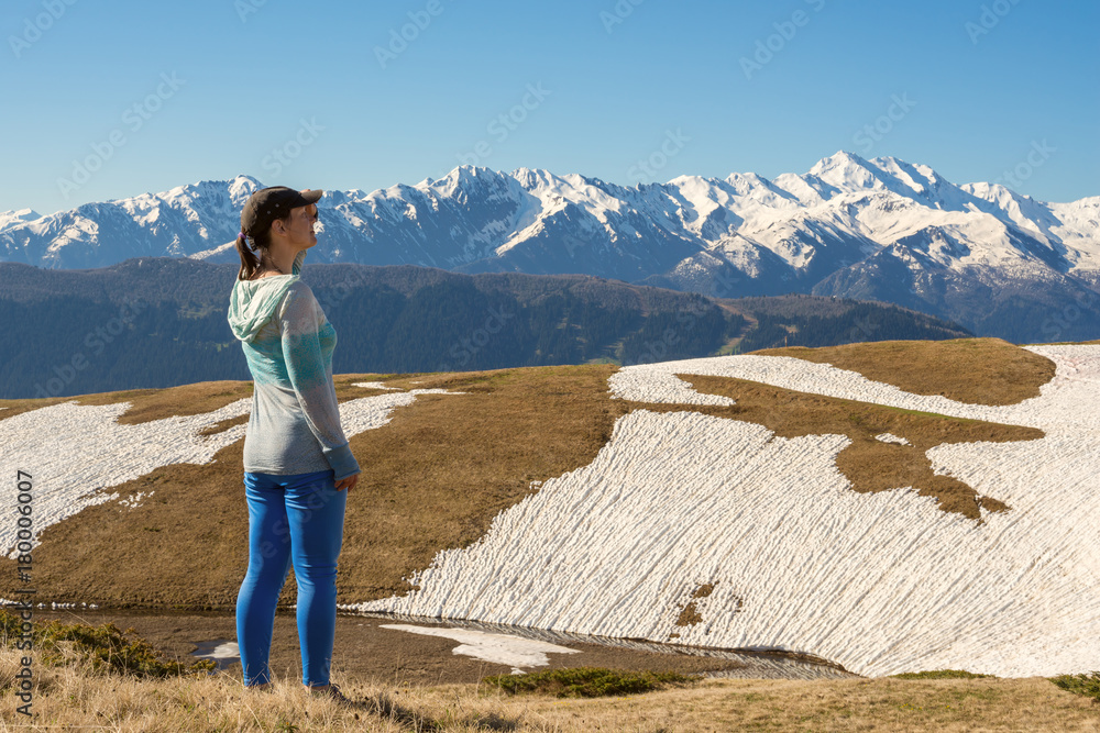 Fototapeta premium Happy woman traveler stands on the mountain plateau