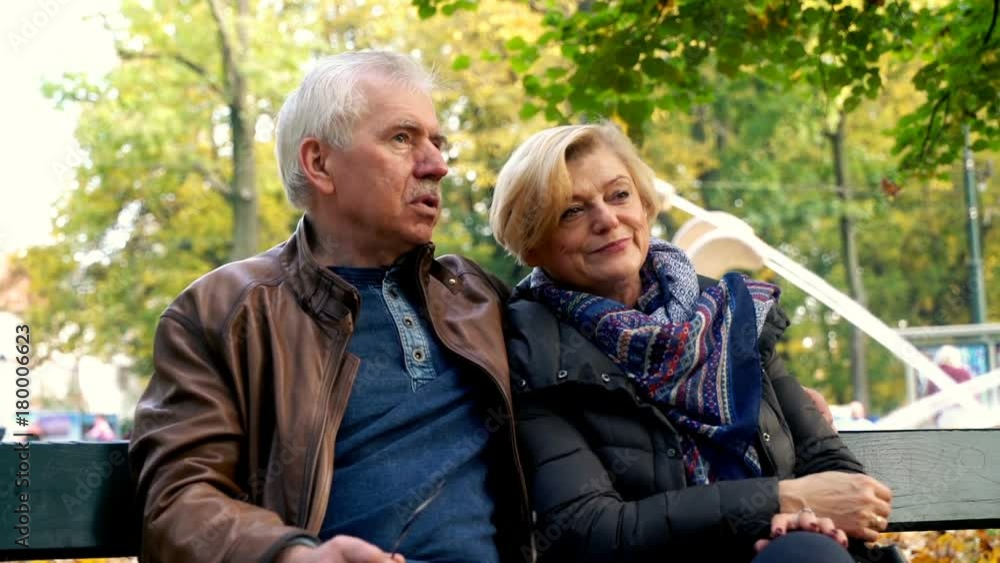 Portrait of happy, mature couple sitting on a bench in the city park
Portrait of happy, mature couple sitting on a bench in the city park