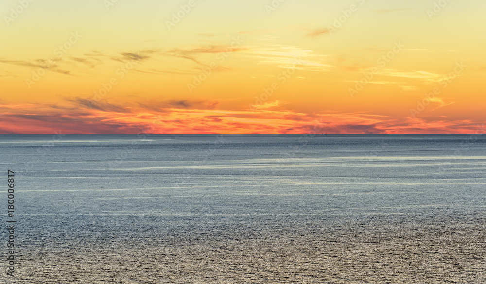 Obraz premium Stylized abstract landscape seascape sunset long exposure with clouds under different shades of blue, orange, yellow and red.