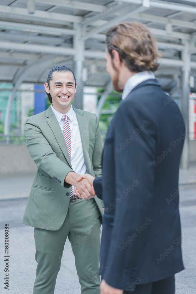 Profession two businessmen shaking hand and smiling after discuss new project success in cityscape background Profession two businessmen shaking hand and smiling after discuss new project success in cityscape background