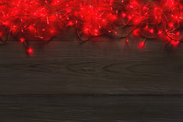 Christmas red lights border on grey wooden background