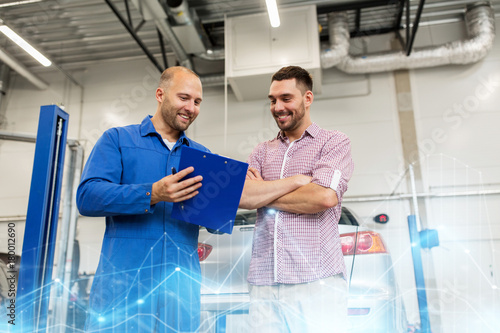 auto mechanic with clipboard and man at car shop