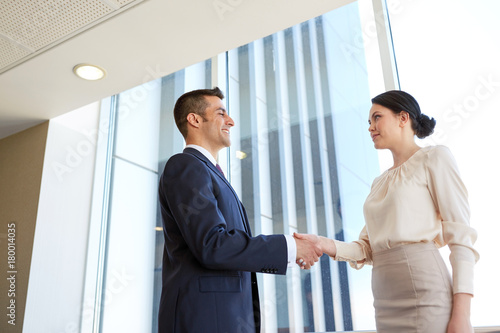 smiling business people shaking hands at office