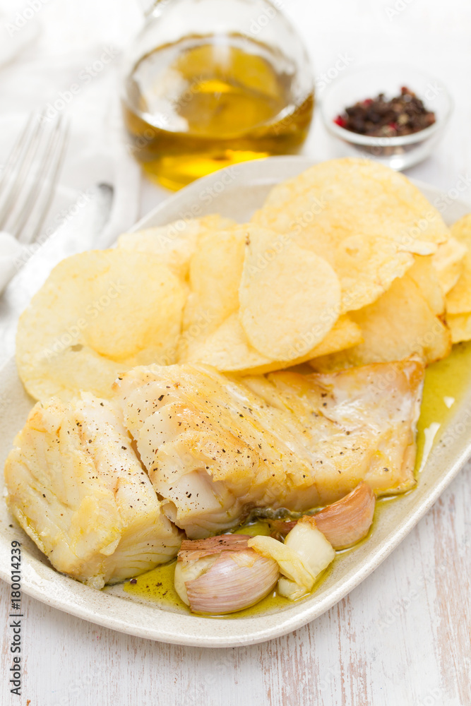 fried codfish with garlic and potato on dish fried codfish with garlic and potato on dish
