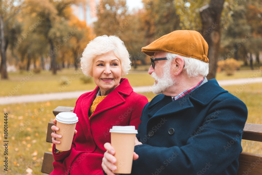senior couple with coffee in park senior couple with coffee in park