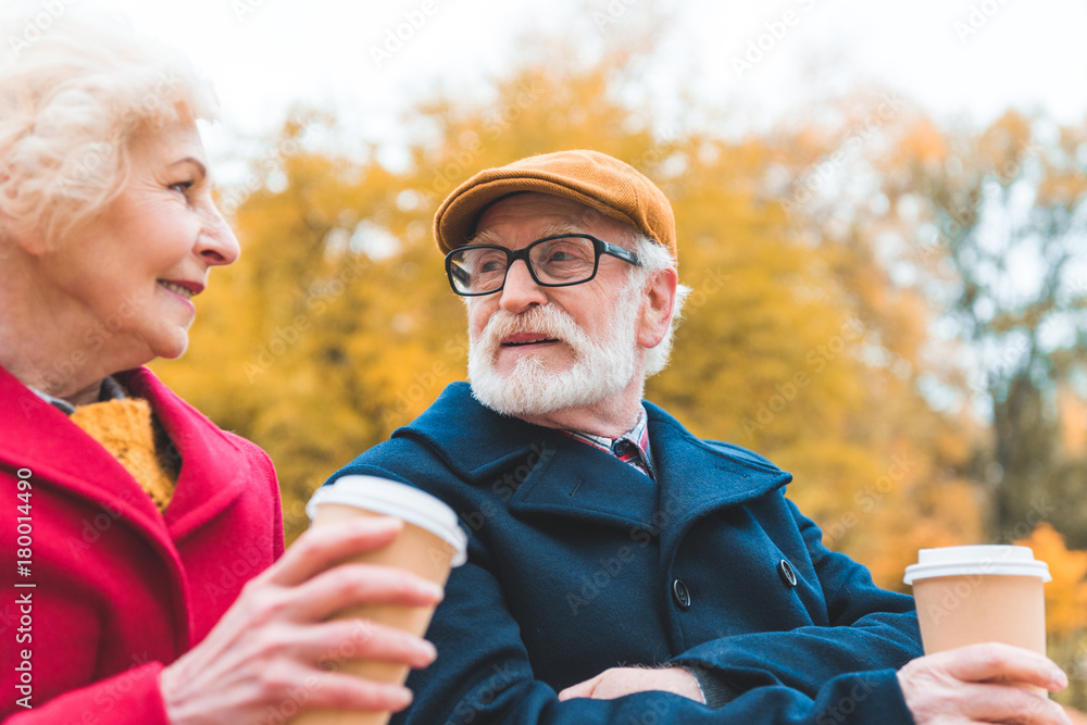 senior couple drinking coffee in park senior couple drinking coffee in park