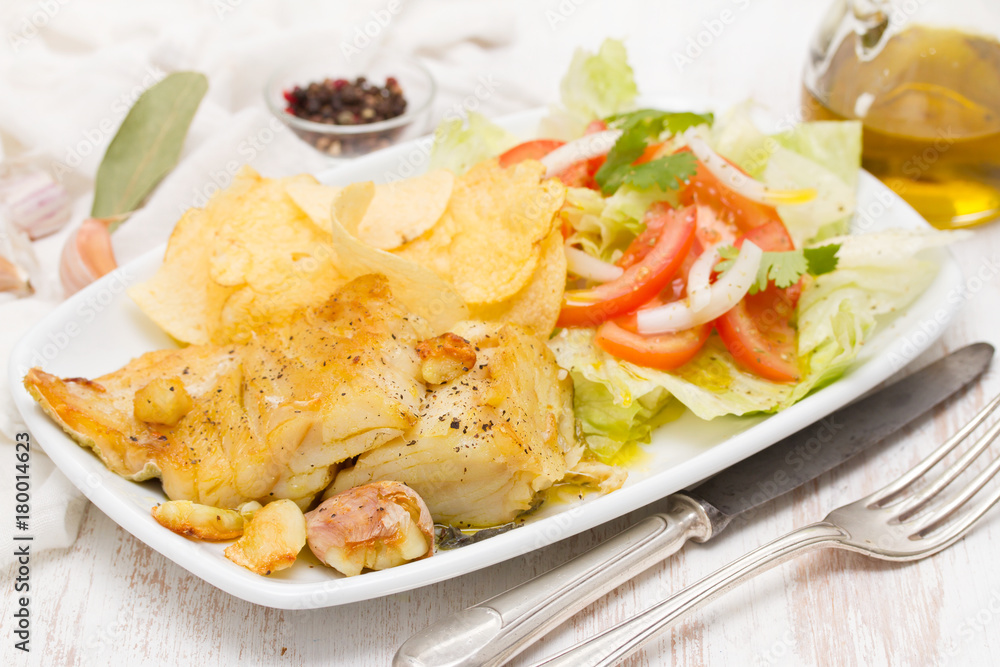 fried codfish with potato and salad on dish fried codfish with potato and salad on dish
