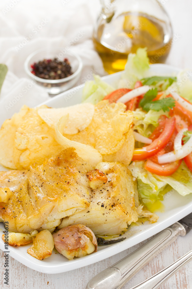 fried codfish with potato and salad on dish fried codfish with potato and salad on dish