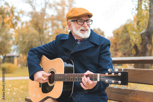 senior man playing on guitar
