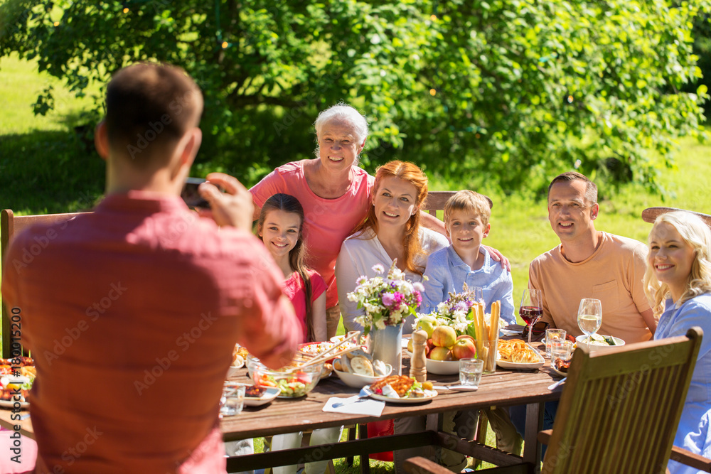 happy family photographing by smartphone in summer happy family photographing by smartphone in summer