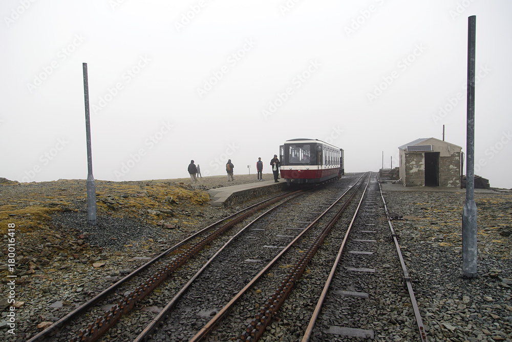 The Snowdon Mountain Railway is a narrow gauge rack and pinion mountain railway in Gwynedd. It is a tourist railway that travels for 4.7 miles from Llanberis to the summit. Mist covers the mountain