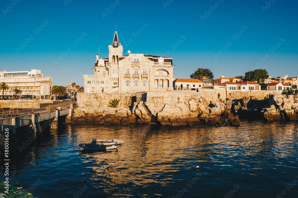 Sea view of Cascais city in Portugal at sunrise with fishing boats visible