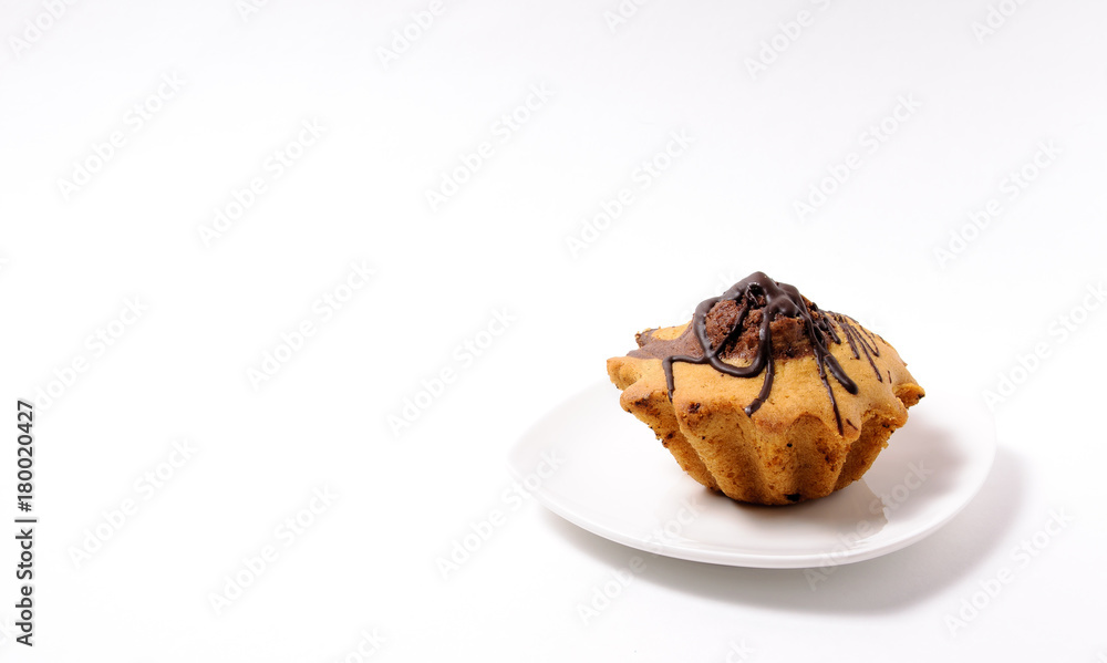 Fresh and flavored cupcake on a white plate on a white background Fresh and flavored cupcake on a white plate on a white background