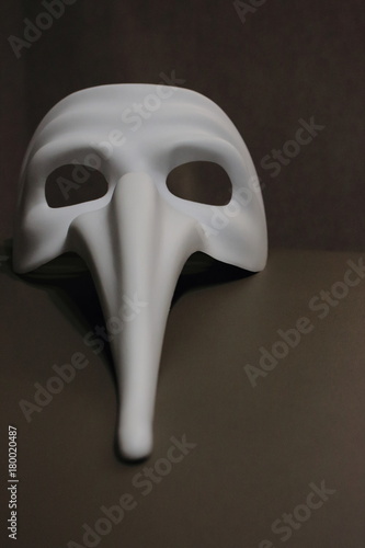 White carnival scary mask doctor plague for fancy dress on beige background. 
