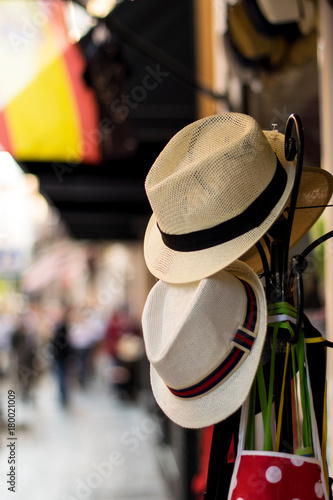 Two hats hanging on a stand in the middle of the street in Seville, Spain