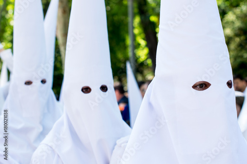 Penitents (Nazarenes) wearing white masks in a Holy Week procession in Seville (Spain) photo