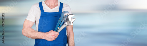 Car mechanic holding wrenches